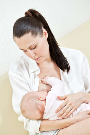 Mother nurse her child on a sofaの写真素材