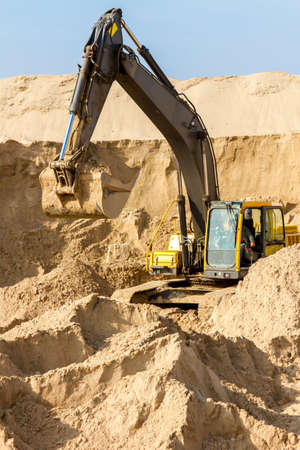 Working Yellow Excavator at Construction Siteの写真素材