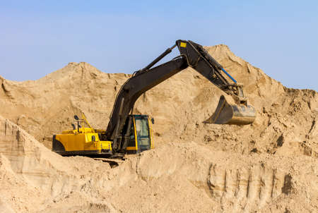 Working Yellow Excavator at Construction Siteの写真素材
