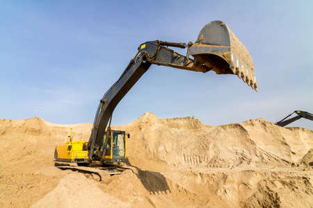 Working Yellow Excavator at Construction Siteの写真素材