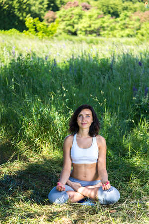 girl doing yoga outdoor with open eyes, verticalの写真素材