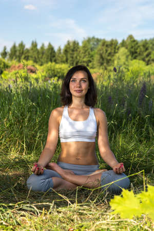 girl doing yoga outdoorr with open eyes, verticalの写真素材