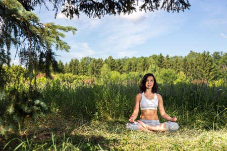 girl doing yoga outdoor with open eyes, ladscapeの写真素材