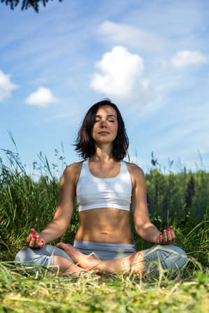 girl doing yoga outdoor with closed eyes, verticalの写真素材