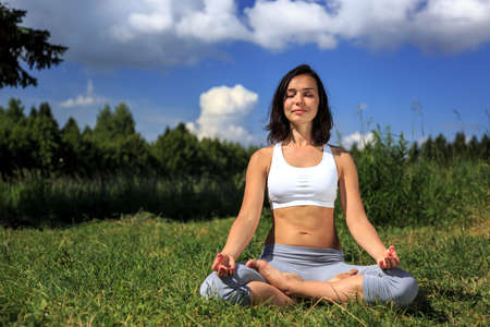girl doing yoga outdoor with closed eyes, ladscapeの写真素材