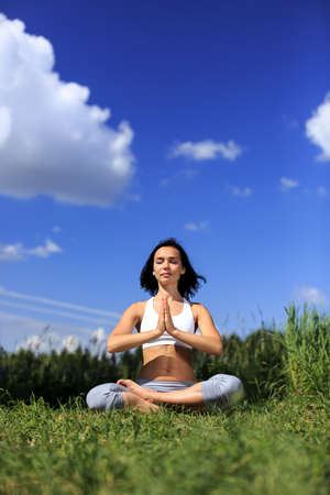 girl doing yoga outdoor with closed eyes, verticalの写真素材