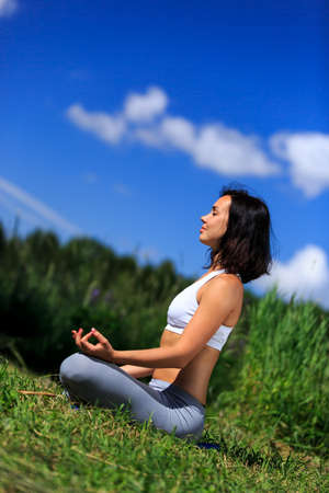 girl doing yoga outdoor with closed eyesの写真素材