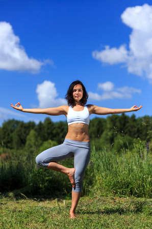 girl doing yoga outdoor with open eyes, verticalの写真素材