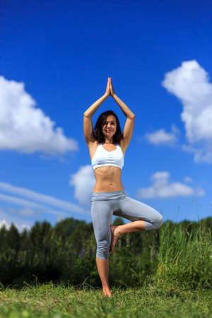 girl doing yoga outdoor with open eyes, verticalの写真素材