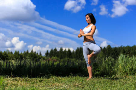 girl doing yoga outdoor with open eyes, ladscapeの写真素材