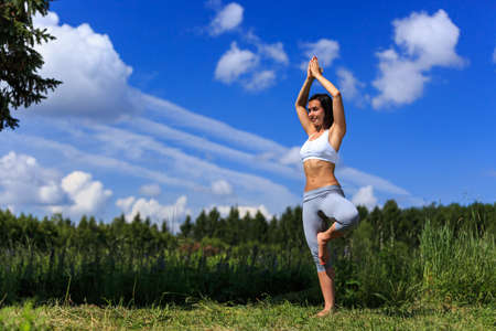 girl doing yoga outdoor with open eyes, ladscapeの写真素材
