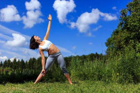 girl doing yoga outdoor and smiling, ladscapeの写真素材