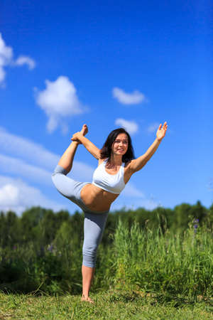 girl doing yoga outdoor with open eyes, verticalの写真素材