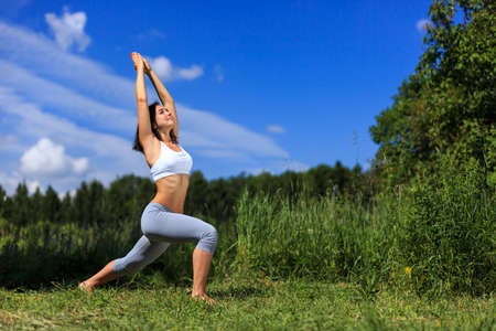 girl doing yoga outdoor and smiling, ladscapeの写真素材