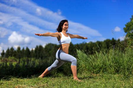 girl doing yoga outdoor with open eyes, ladscapeの写真素材