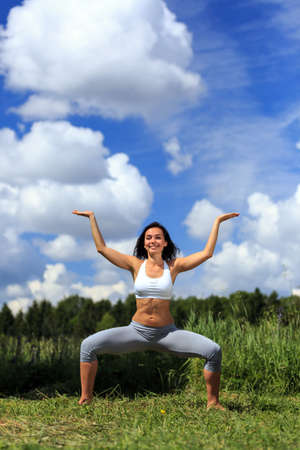 girl doing yoga outdoor looking in camera and smilingの写真素材