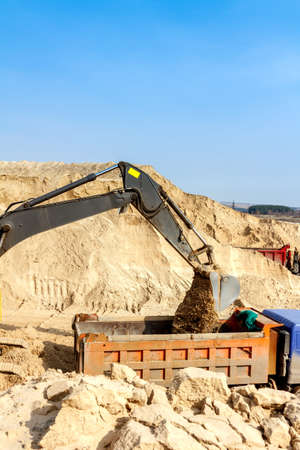 Excavator Loading Dumper Truck at Construction Site