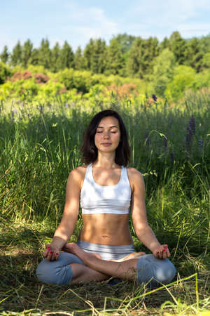 girl doing yoga outdoor with closed eyes, verticalの写真素材