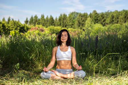 girl doing yoga outdoor with closed eyes, ladscapeの写真素材