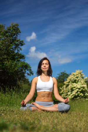 girl doing yoga outdoor with closed eyes, verticalの写真素材