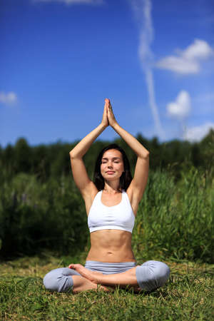 girl doing yoga outdoor with closed eyes, verticalの写真素材
