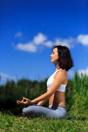 girl doing yoga outdoor with closed eyes, verticalの写真素材