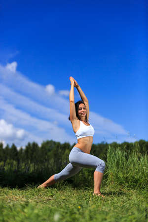 girl doing yoga outdoor looking in camera, verticalの写真素材