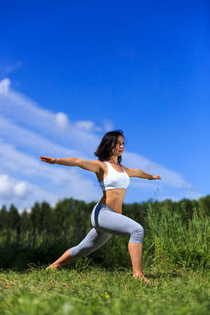 girl doing yoga outdoor with open eyes, verticalの写真素材