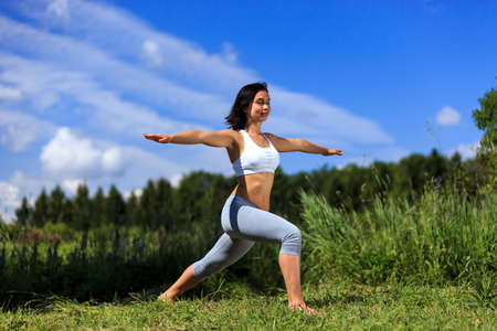 girl doing yoga outdoor with closed eyes, ladscapeの写真素材