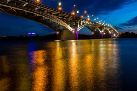 Bridge at a quiet night in Nizhny Novgorod with blurred reflectionsの写真素材