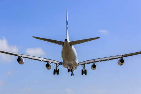 airplane landing in bright Blue sky, right before touch-down. Rear View.の写真素材