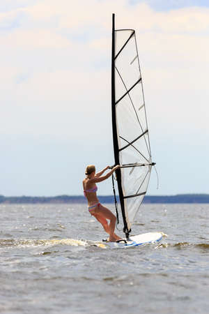 Rear view of woman windsurfing in splashes of waterの写真素材