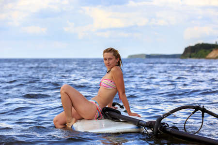 Happy windsurfer take a rest on the boardの写真素材