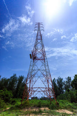 Super wide angle photograph of Electricity pylon with blue sky and sunの写真素材