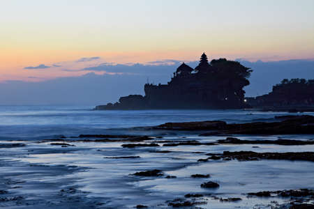 Tanah Lot Temple and ocean waves at sunset, Bali, Indonesiaの写真素材