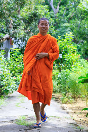 Young Buddhist Monk Walking And Smiling To The Cameraの写真素材