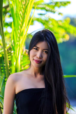 Close-up portrait young beautiful Asian girl smile with palm treeの写真素材