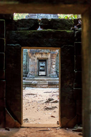 Ancient stone door in ruins of  buddhist khmer temple near Siem Reap, Cambodiaの写真素材