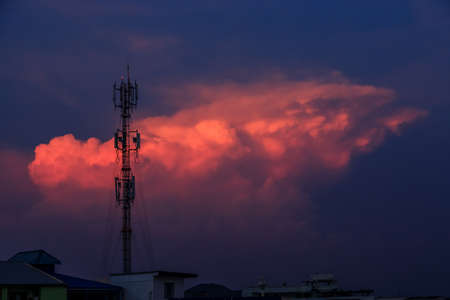 Silhouette signal antenna tower at beautiful sunset sky background