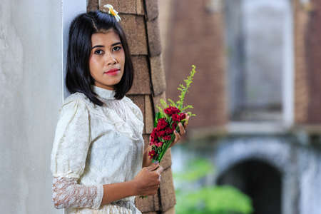Beautiful Woman with Thai Traditional Dress King Rama 5 posing in old buildingの写真素材