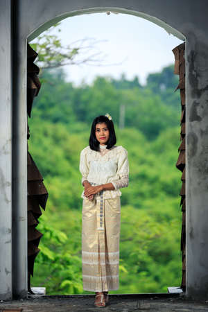 Beautiful Woman with Thai Traditional Dress King Rama 5 posing in old buildingの写真素材