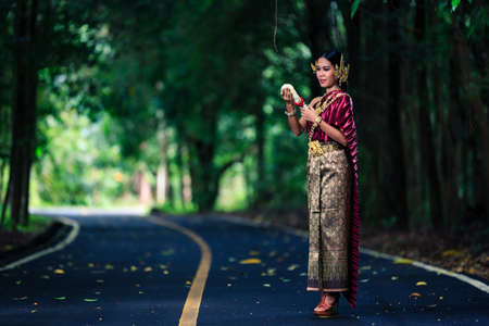 Beautiful Woman with Thai Traditional Dress King Rama posing in the tropical forestの写真素材