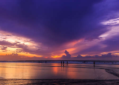 Magic Dramatic Unreal Sunset with people silhouettes in Kuta beach, Bali, Indonesiaの写真素材