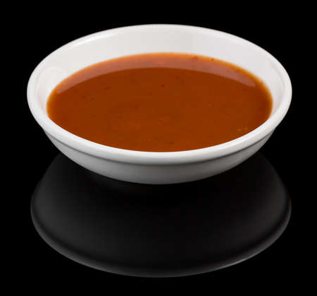 Bowl of Sweet and Chilli sauce with reflection isolated on black backgroundの写真素材