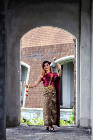 Beautiful Woman with Thai Traditional Dress King Rama 1 dancing in ruined buildingの写真素材