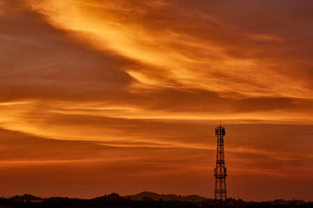 Silhouette signal antenna tower at beautiful sunrise sky backgroundの写真素材