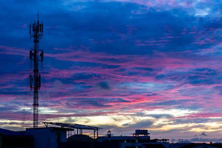Silhouette signal antenna tower at beautiful sunset sky background