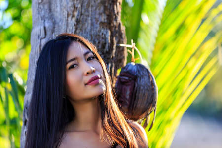 Close-up portrait young beautiful Asian girl smile with palm treeの写真素材