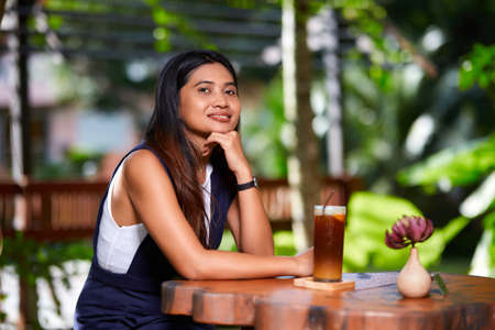 Close-Up portrait of young asian woman posing at the table in cafeの写真素材