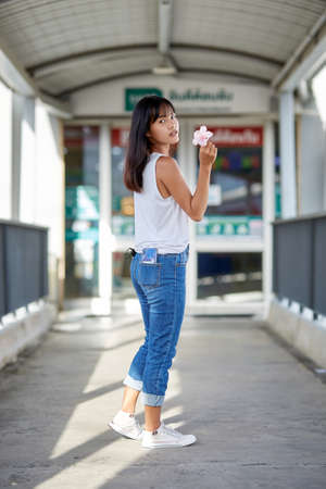 Outdoor fashion portrait of young Asian woman posing in the corridorの写真素材